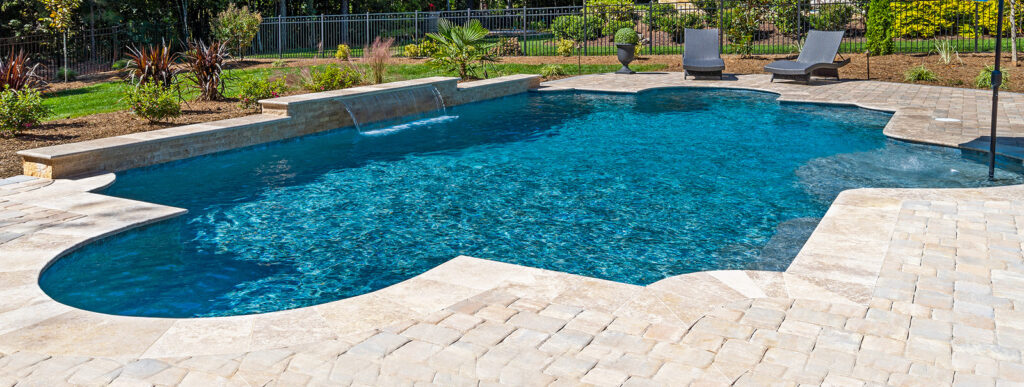 Roman-shape pool in Greenville, SC with paver deck.