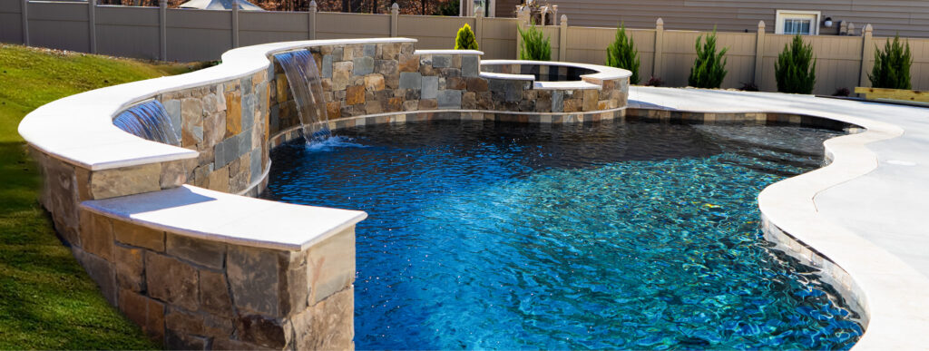 Spartanburg inground pool with dark blue-green water and curvy shape.