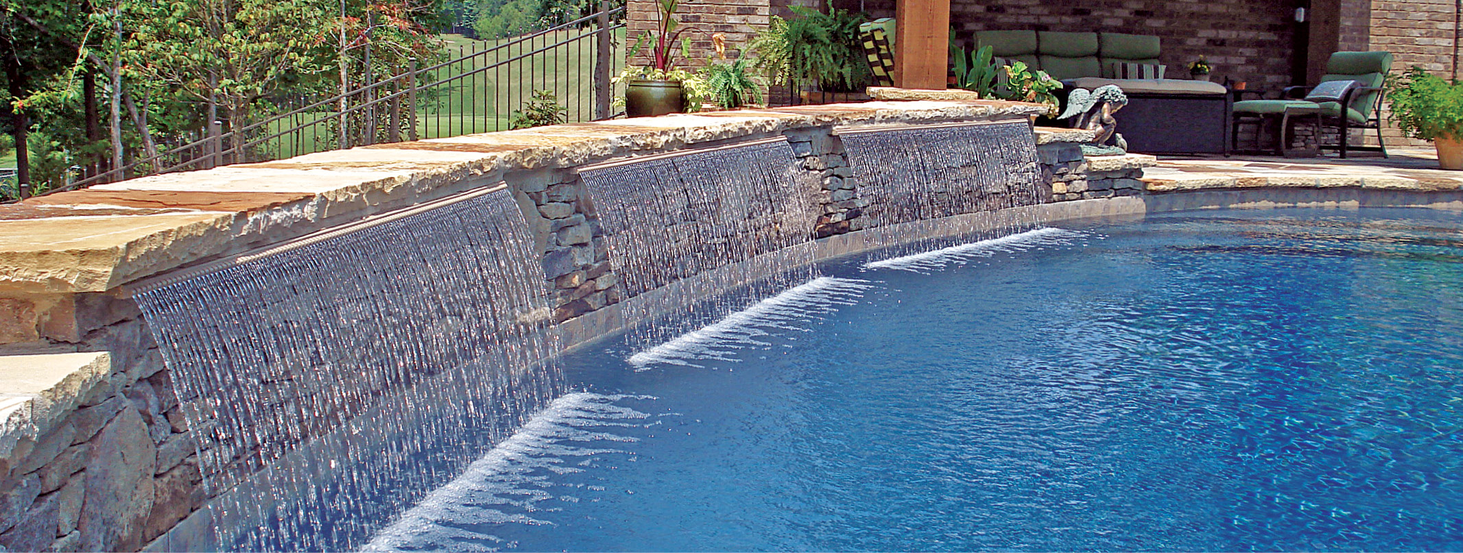 Teardrop-style cascade water features on a swimming pool in Greenville backyard,
