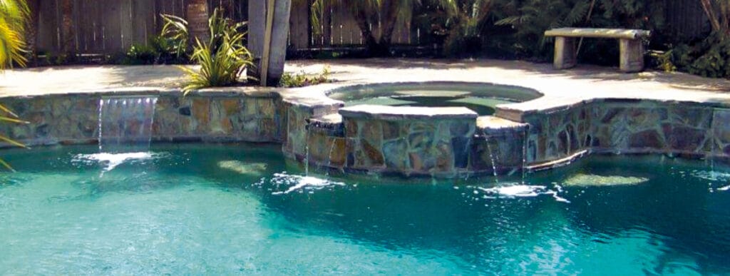 Spa with rough-cut multicolored flagstones facing on swimming pool