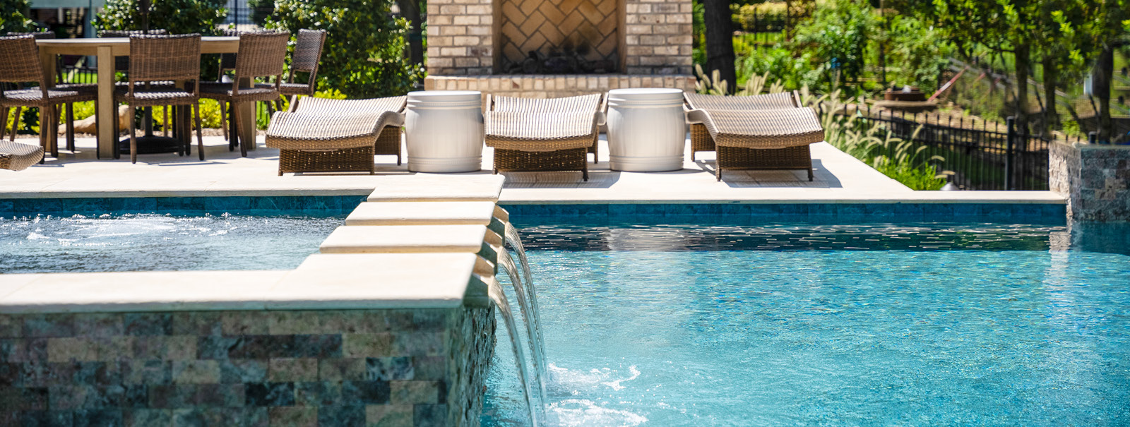 Custom spa with channel spillways on a gunite pool.