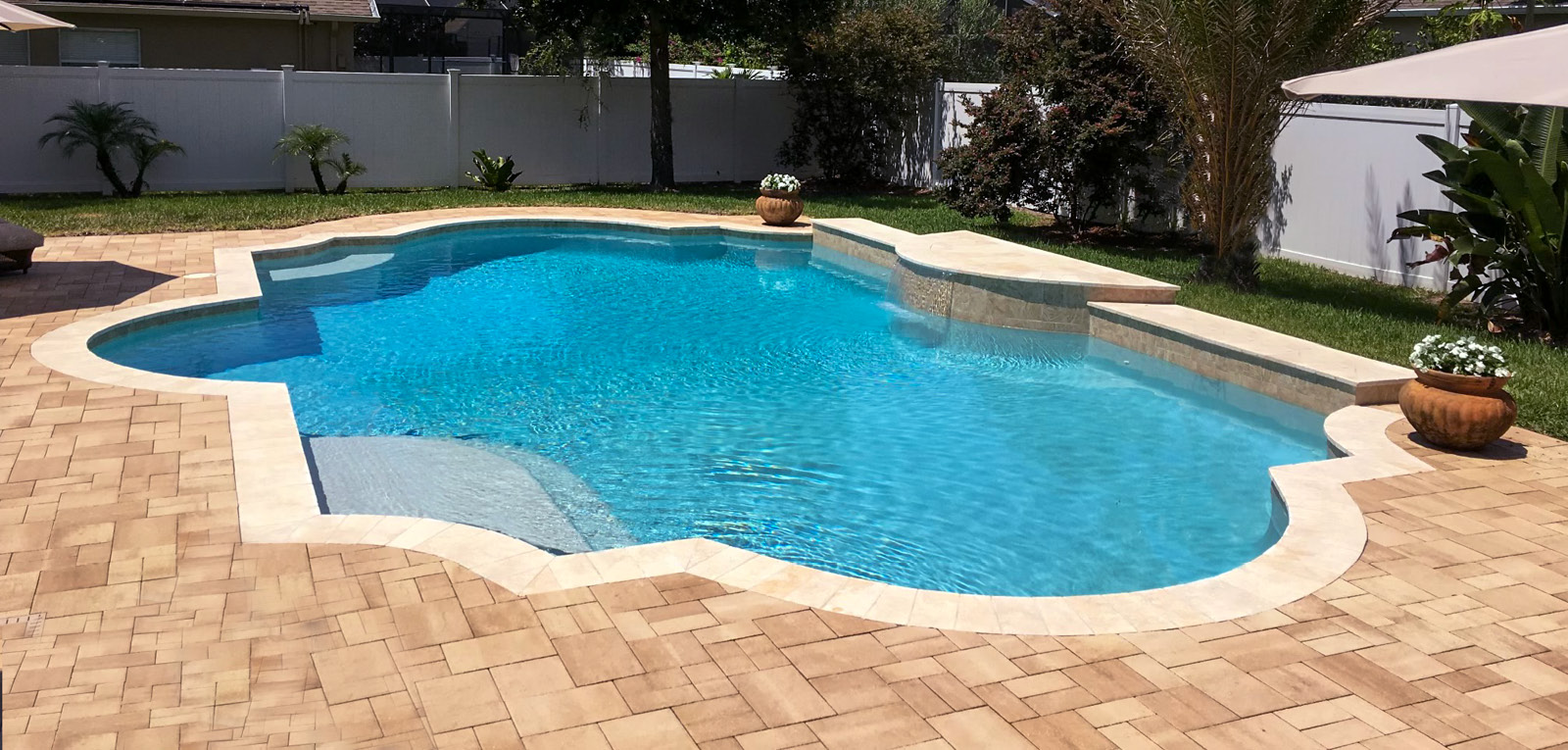 Inground pool with a modified Roman shape.