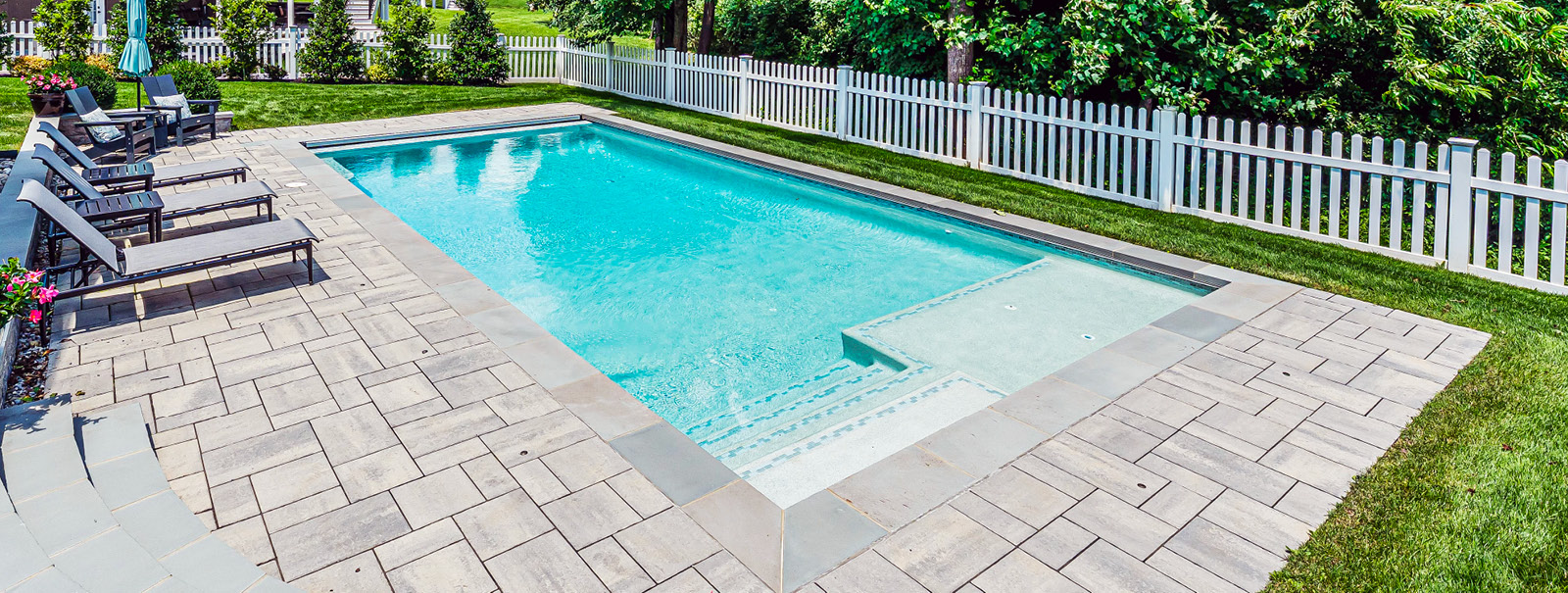 Rectangular gunite pool with tile-accented entry steps and tanning ledge in Loudon County.