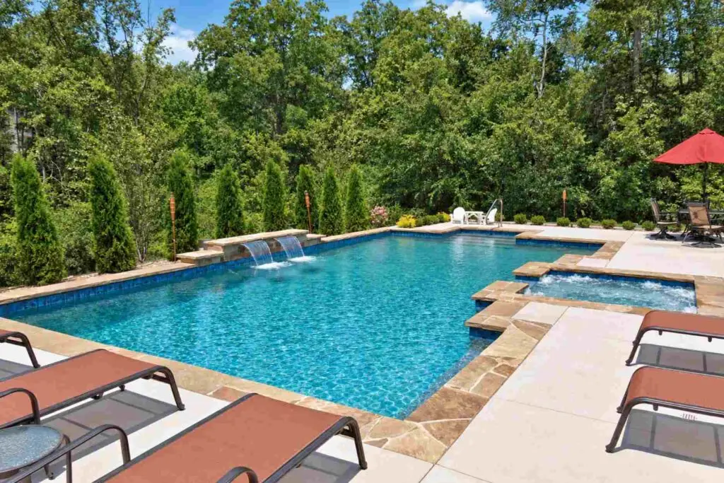 Crystal clear blue swimming pool with sheer descent water features and attached spa