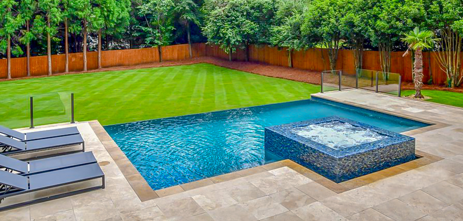 Rectangular infinity swimming pool with a square, bubbling spa.