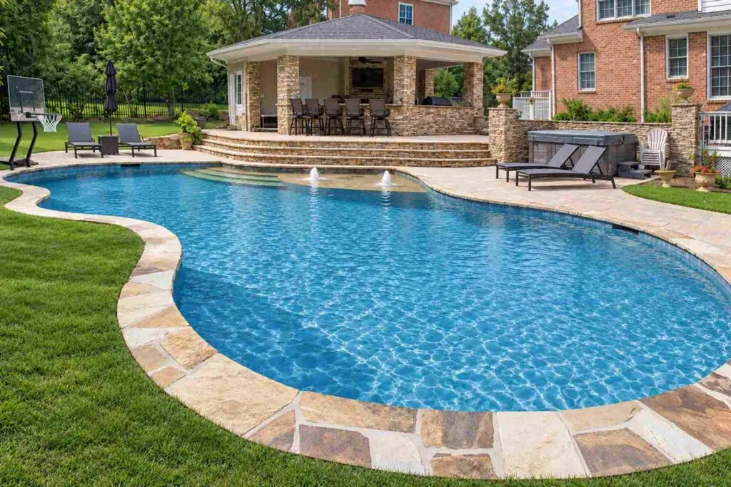 Natural-shape flagstone pool coping around a freeform pool bordered by grass