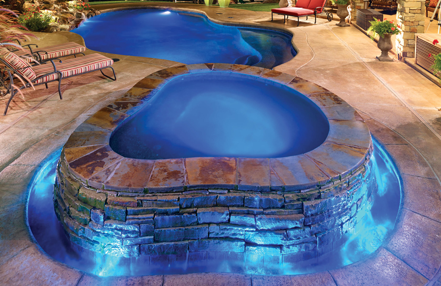 Organic shaped rimflow spa built into luxury swimming pool