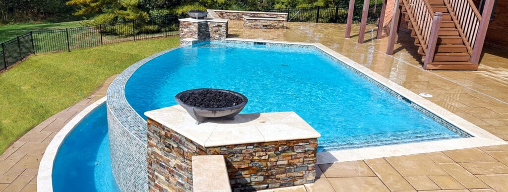 Custom pool with curved vanishing edge in Louisville backyard.