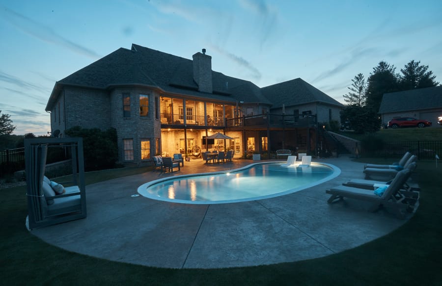Illuminated backyard swimming pool at dusk