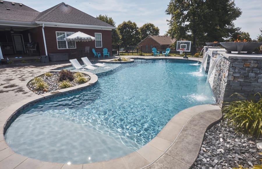 Freeform swimming pool with waterfall wall and landscaping