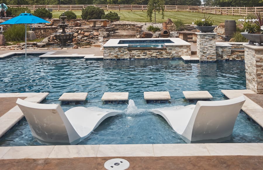 Geometric swimming pool with sunken lounge chairs and raised spa