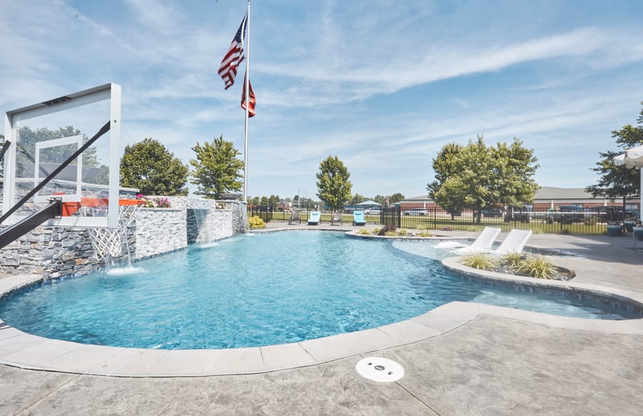 swimming pool with basketball hoop, waterfalls and in-pool loungers