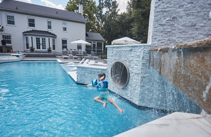 Swimming pool with waterfall wall and raised spa
