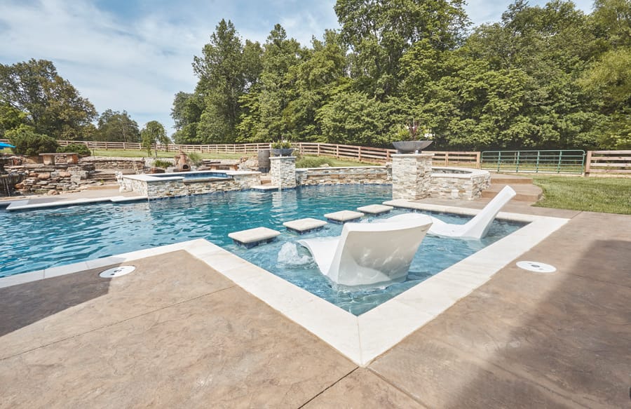 Shallow pool lounging area with submerged chairs and stepping stones