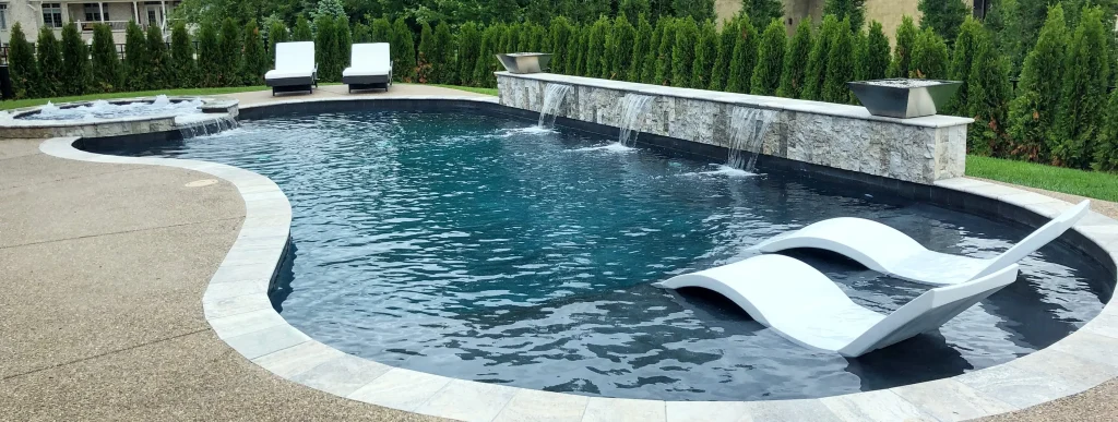 Curvy pool with bubbling spa and tanning ledge in Indianapolis backyard.