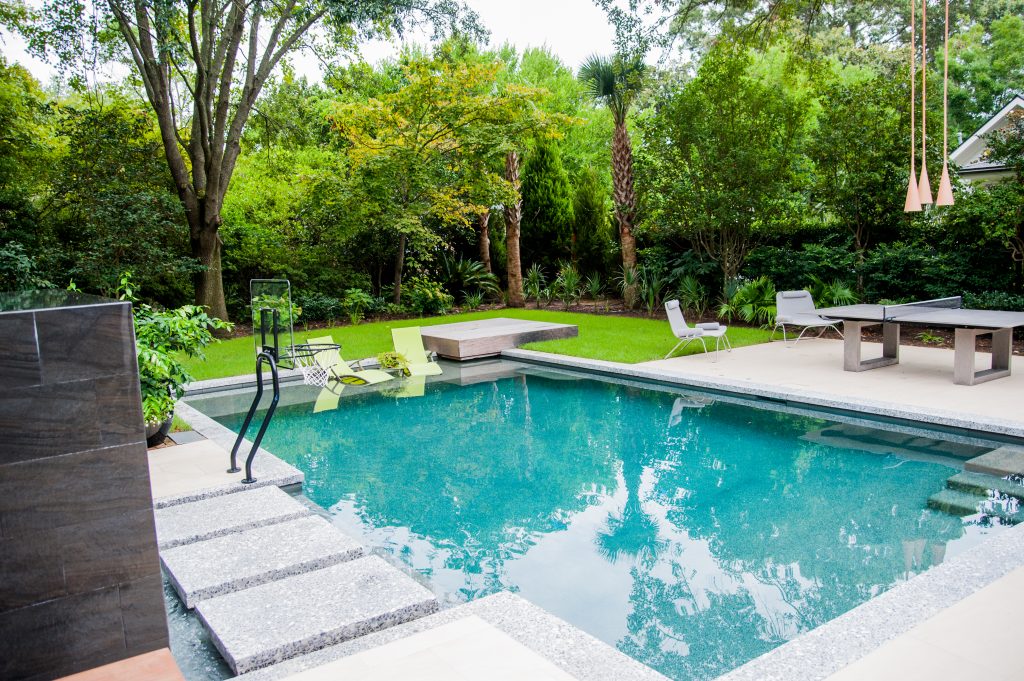 Custom backyard swimming pool with premium hardscape and landscaping