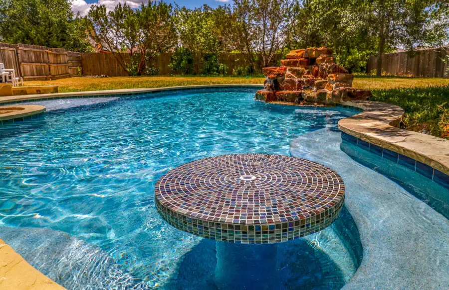 Custom inground swimming pool design with modern backyard layout in San Antonio