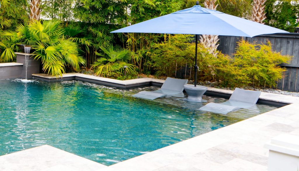 Luxury pool tanning ledge with built-in lounging area and shallow shelf