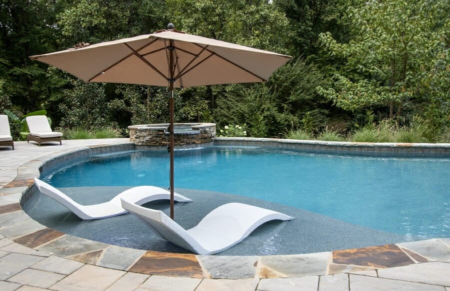 Chaise lounge chairs placed on a swimming pool sun shelf
