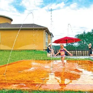 Concrete splash pad with water sprayers for family fun