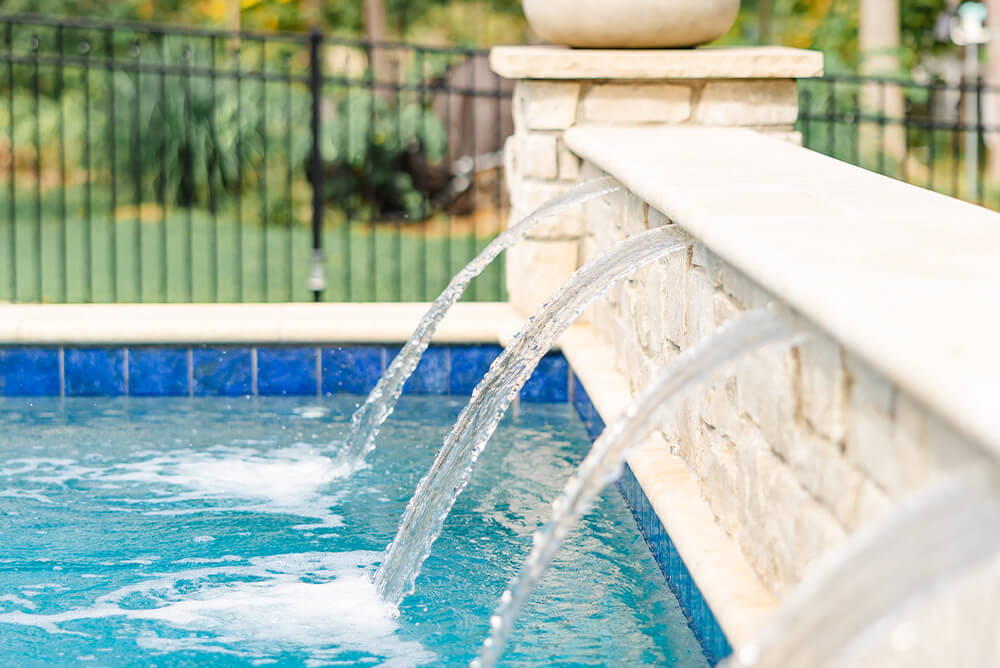 Enhance geometric pool using arc waterfall and stone pillar