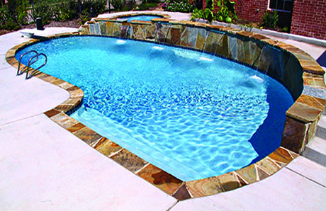 Geometric swimming pool with cascade water features and smooth plaster finish