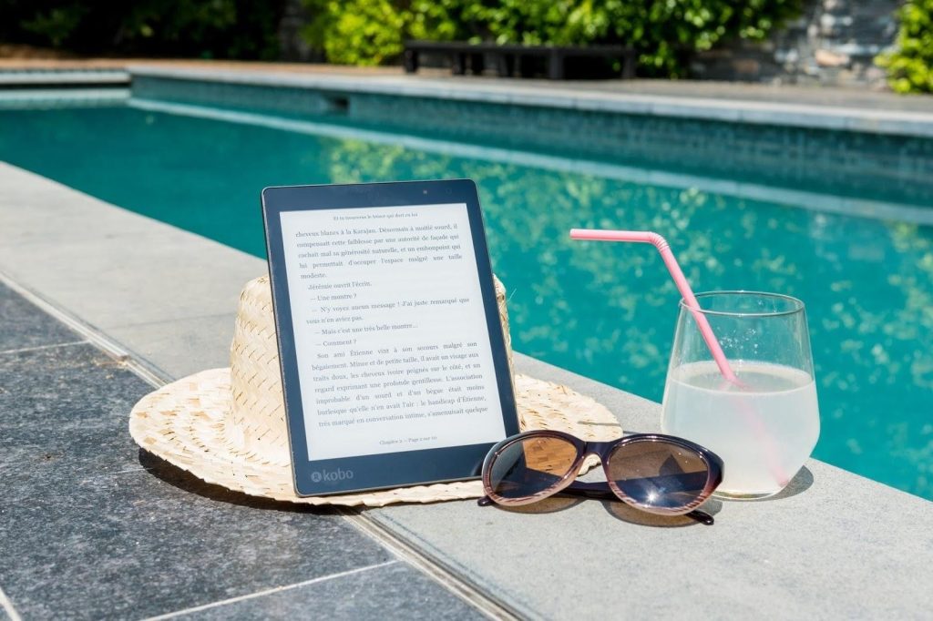 Sun hat and sunglasses placed beside a relaxing poolside setting