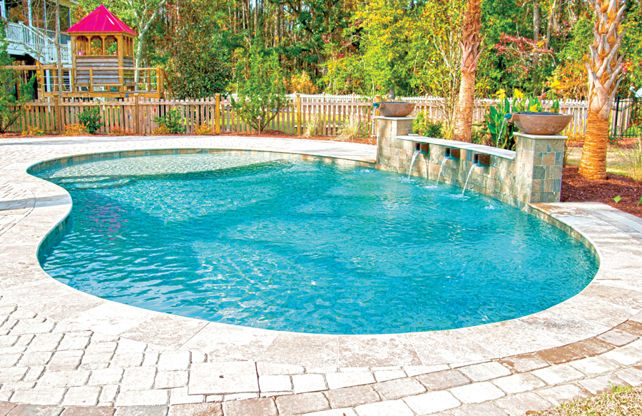 Kidney-shaped swimming pool with decorative water feature wall