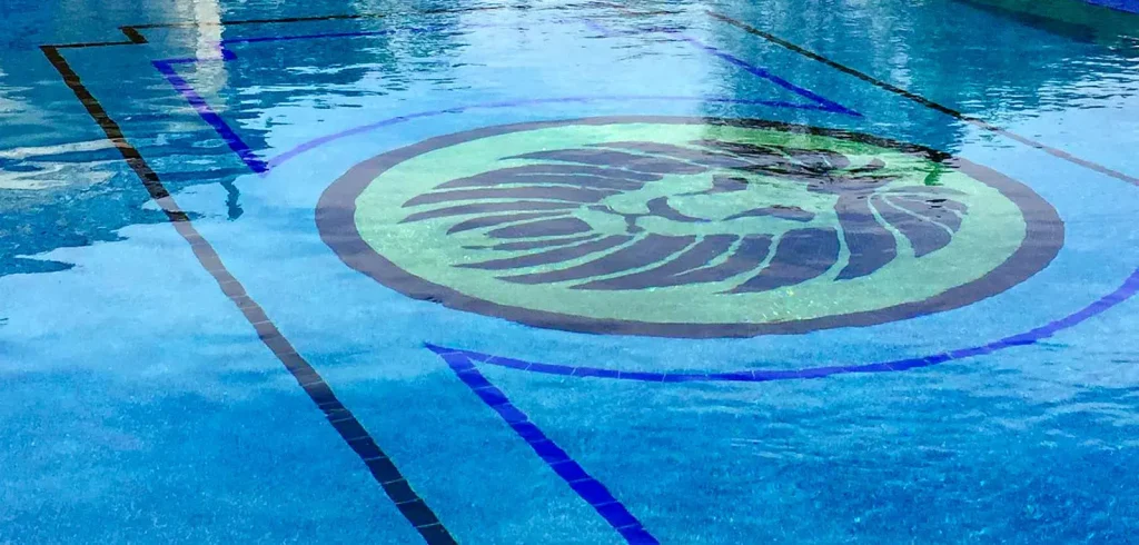 Inground swimming pool featuring decorative mosaic tile artwork